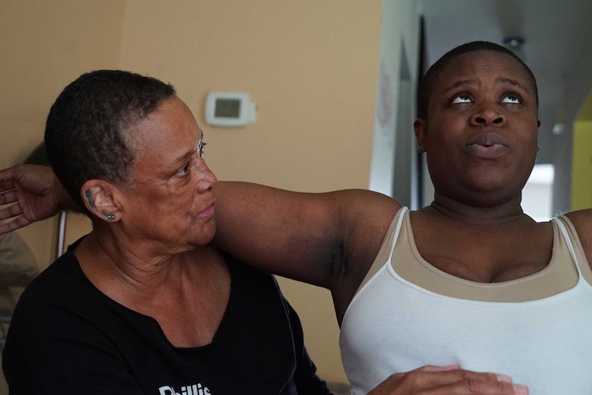 Binahkaye Joy looks at the ceiling as midwife Claudia guides her through a stretch.