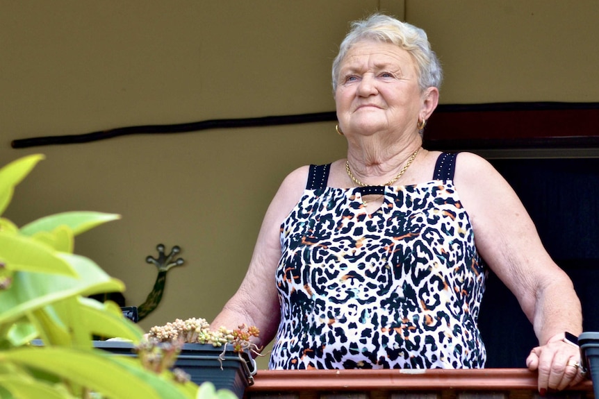 Lyn Farley stands on a verandah looking out past the camera.