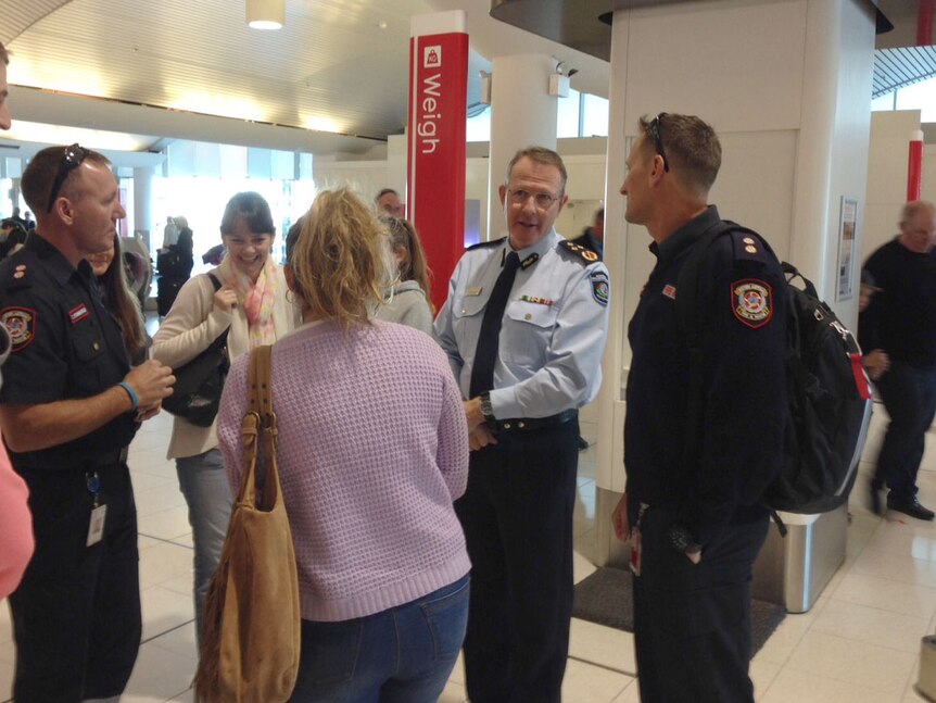 DFES deputy commissioner Steve Fewster talks to firefighters and family members at Perth airport