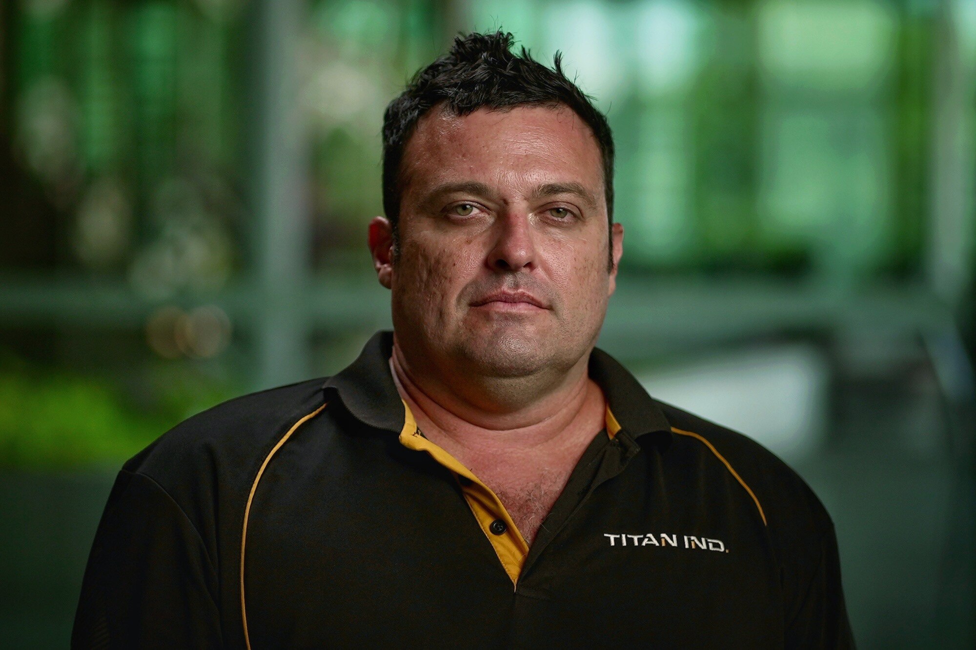 A serious-looking man in a dark shirt.