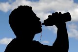 A sportsman takes a drink following a training session.
