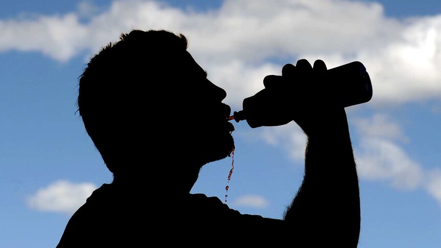 A sportsman takes a drink following a training session.