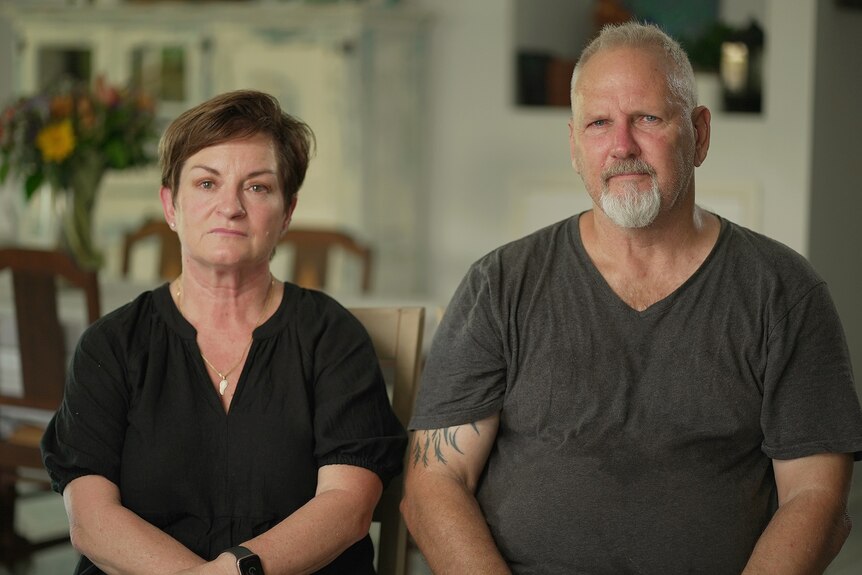Grieving parents Megan and Ron Moore look solemn as they sit together in their house.