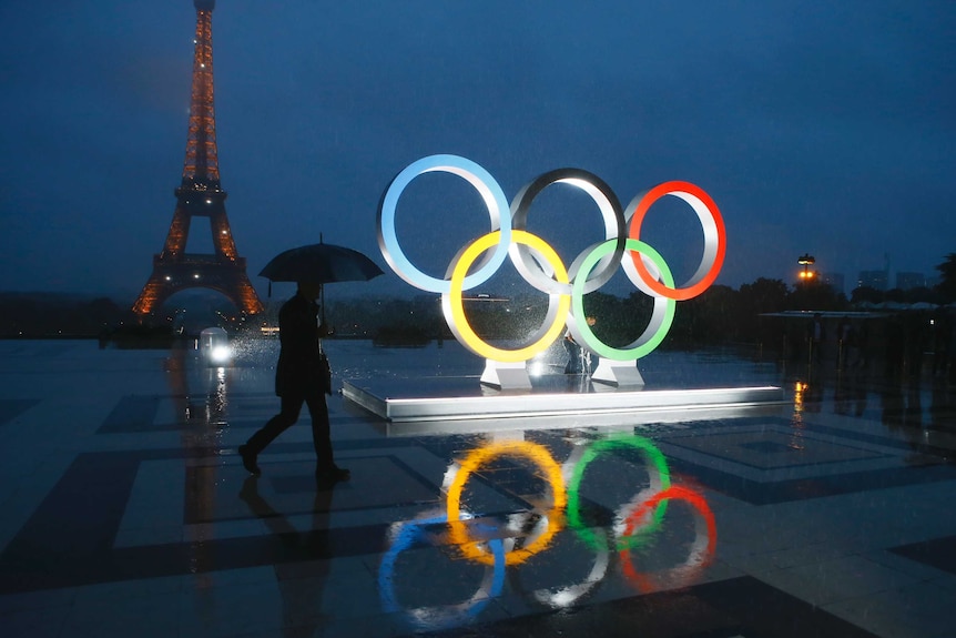 Olympics rings are lit up in front of the Eiffel Tower.