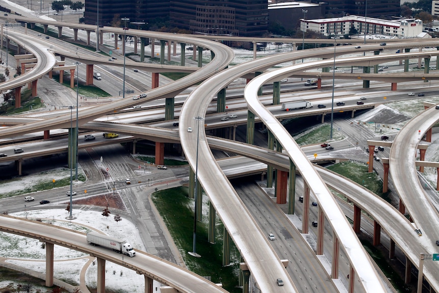 The Hi-Five interchange where LBJ Freeway and Hwy 75 connect is shown with vehicles on a snowy and icy road