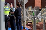Police stand near the scene of a fatal wall collapse