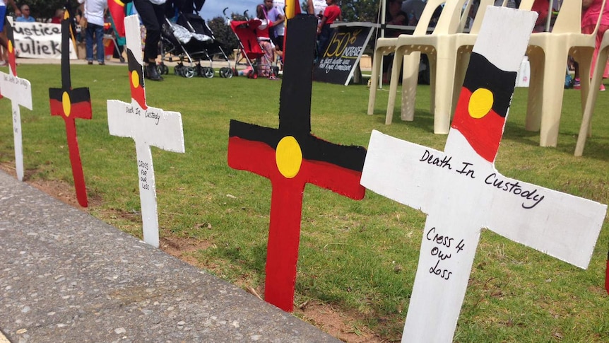 Protesters gather in Geraldton behind a row of crosses representing deaths in custody