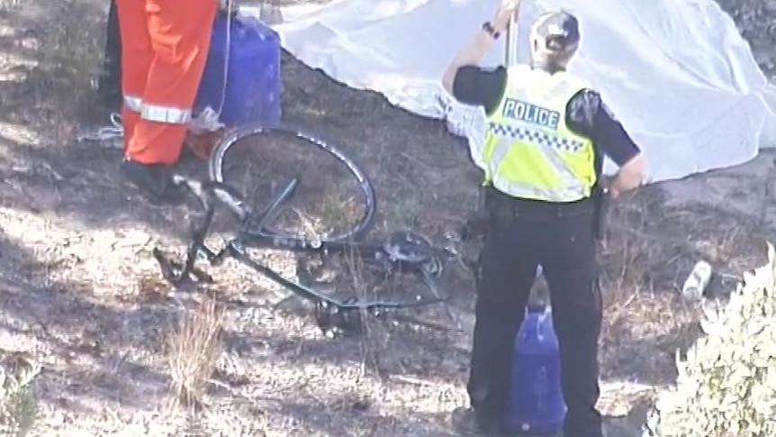 A police officer looking at a bicycle