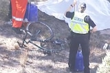 A police officer looking at a bicycle