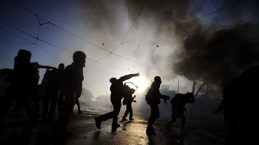 Protestors attack a police vehicle during a demonstration, in Rome on October 15, 2011.