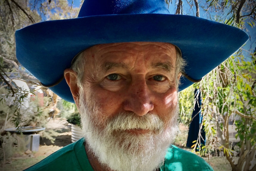 man with white facial hair and blue hat. 