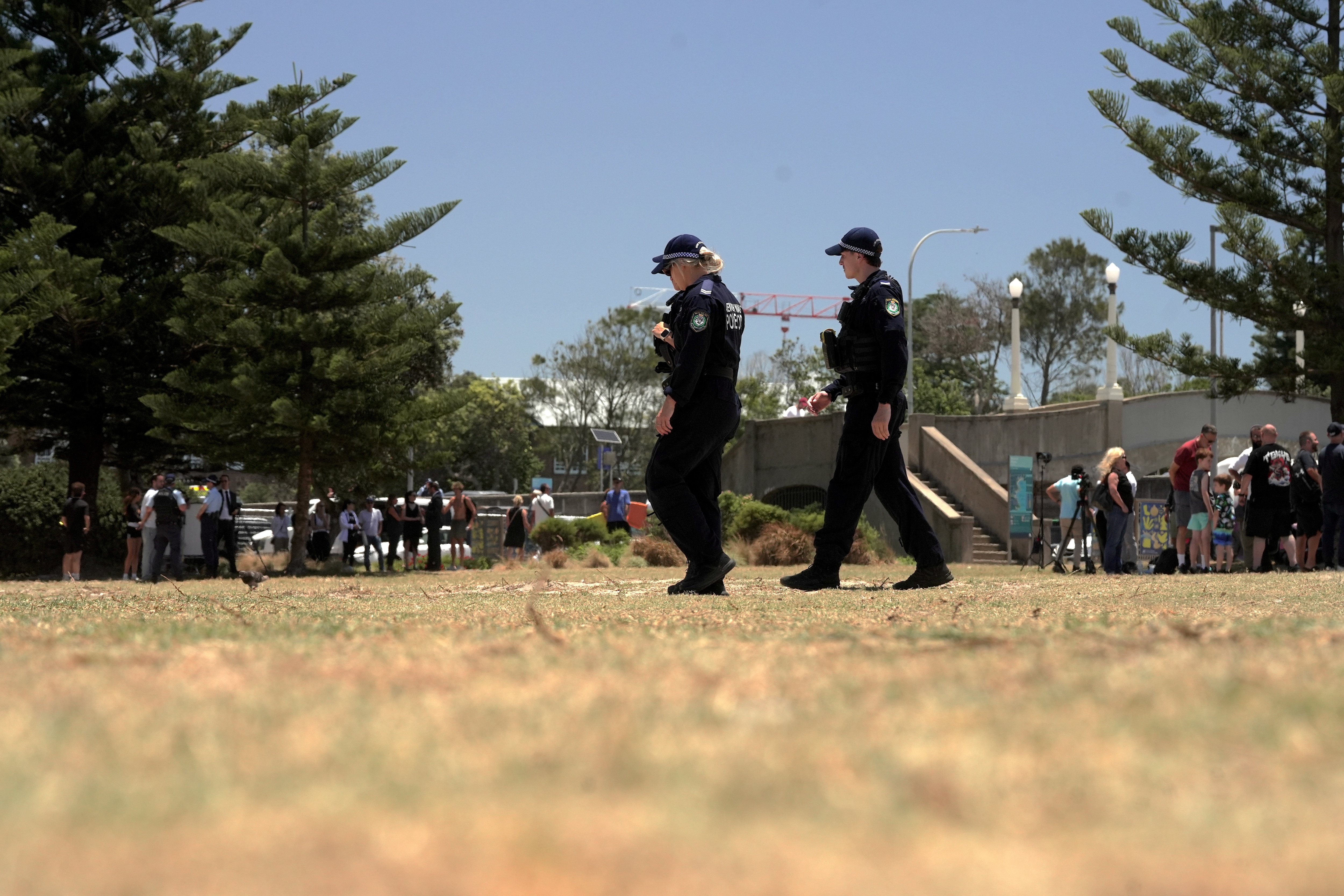 Dos policías caminan por un parque.