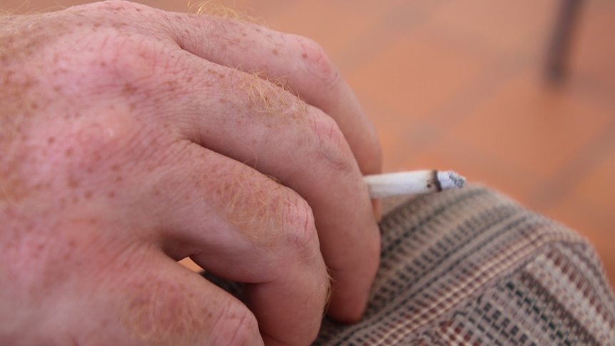 A man holding a cigarette in his hand