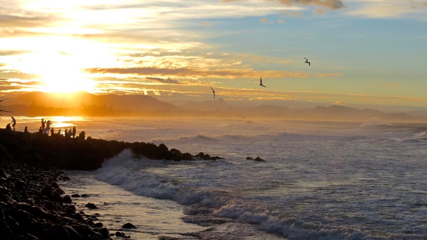 Local and tourists gazing into the sunset