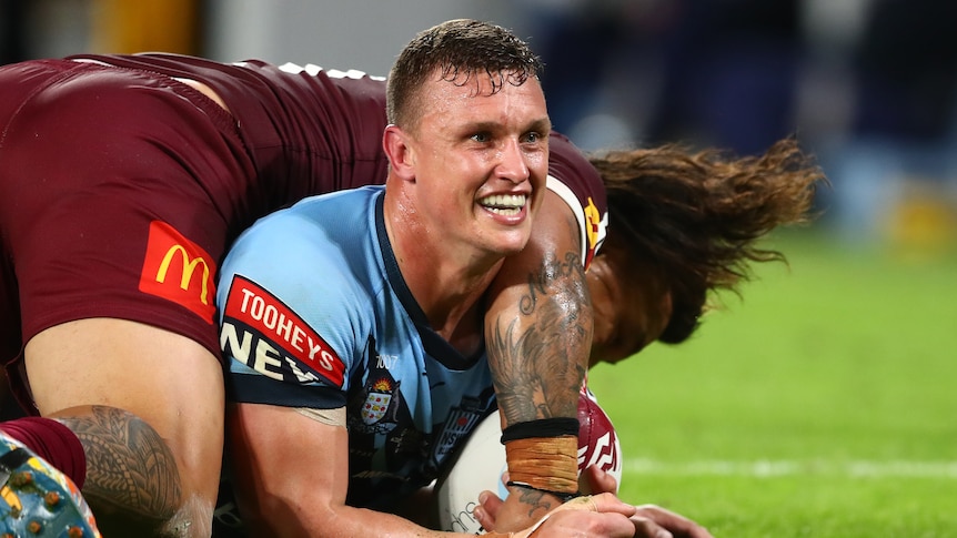 A man celebrates scoring a try in a State of Origin match