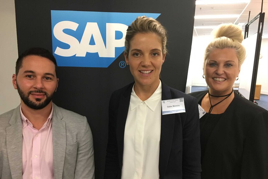 Gabe Marzano (centre) with two representatives from SAP Australia stand smiling at a Veterans career day