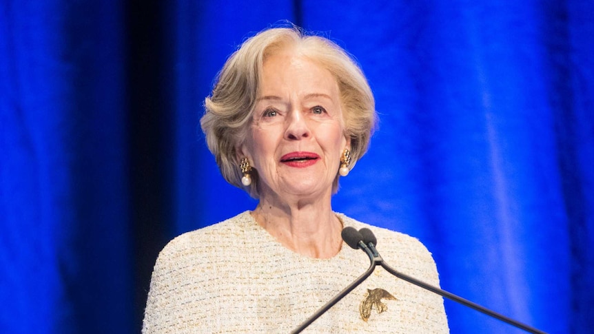 A woman wearing a dress at a lectern