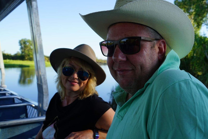 Tourists Sue Atkins and Simon Homann are smiling and sit on a boat on Yellow Water billabong in Kakadu.