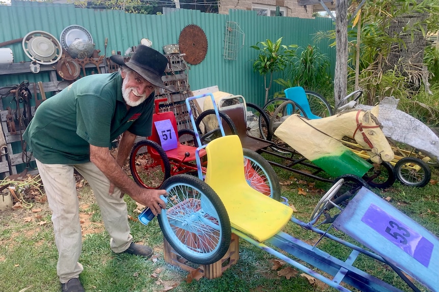 Man spray-painting billy cart wheel