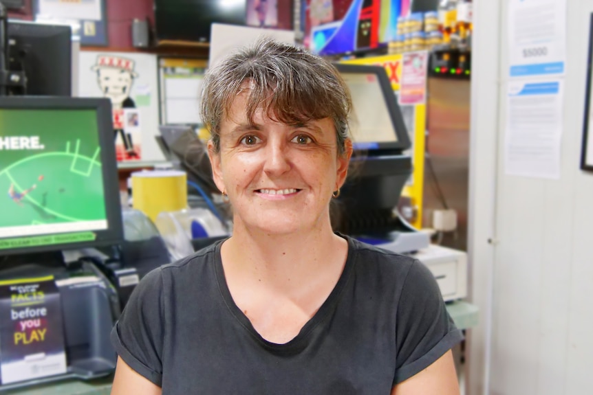woman in black shirt inside pub smiles at camera