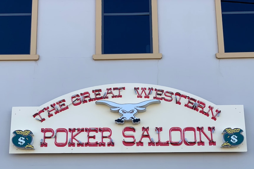 a neon sign which reads the great western poker saloon