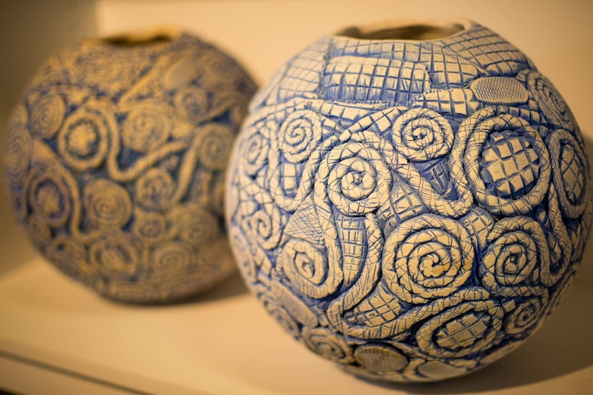 Two blue oxide pots on a shelf.