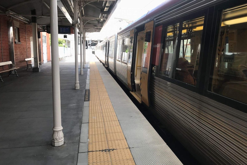 A train stops at an empty station with no one on the platform