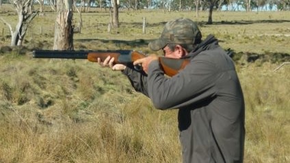 Man shooting with his dog.