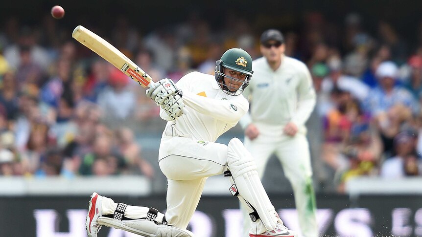 An Australian batsman goes on one knee to hit a leg-side boundary in a Test match.