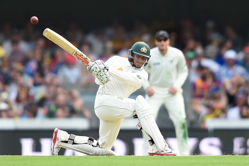 An Australian batsman goes on one knee to hit a leg-side boundary in a Test match.