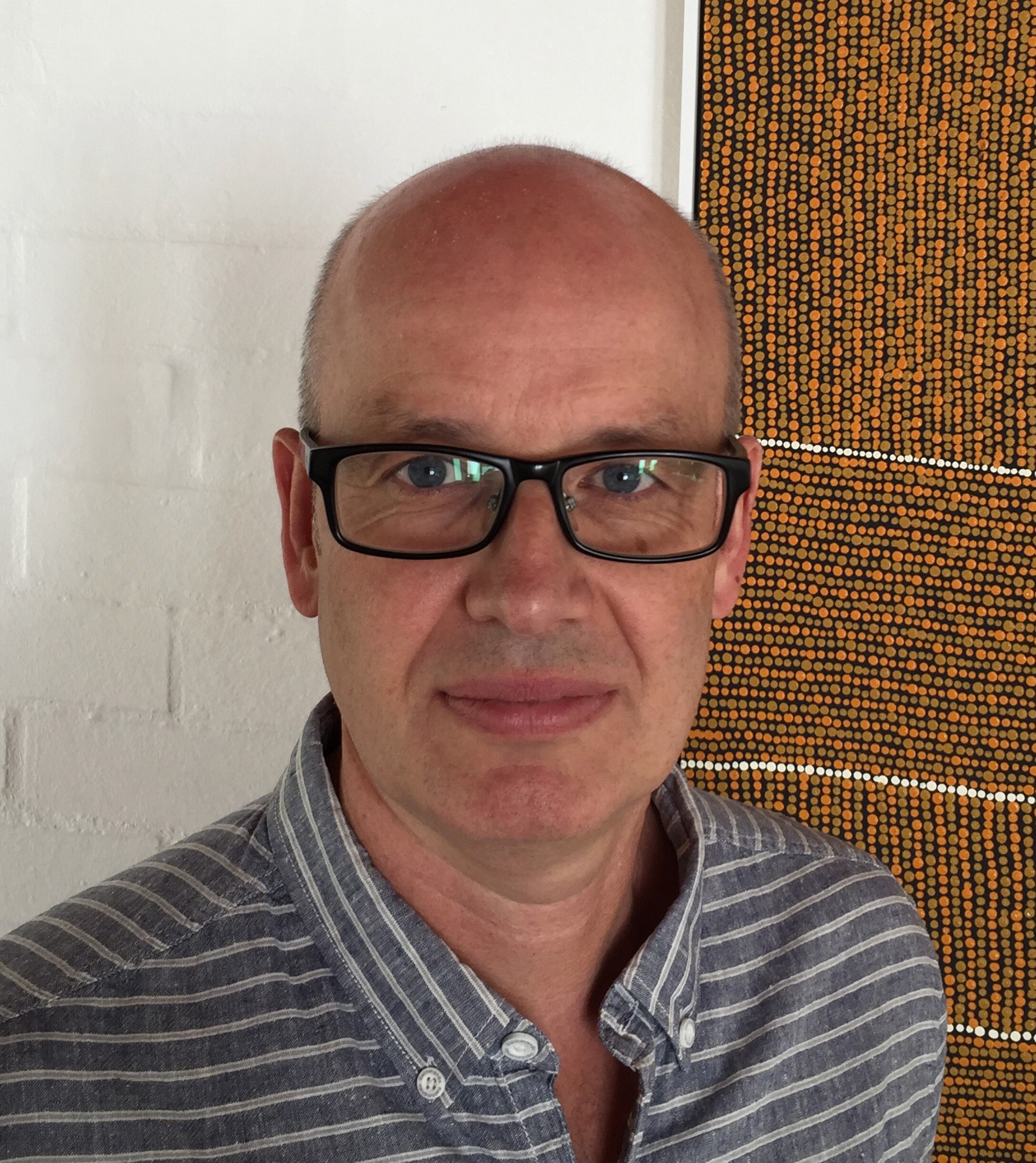 Scientist Eddie Holmes wearing glasses and a striped shirt.