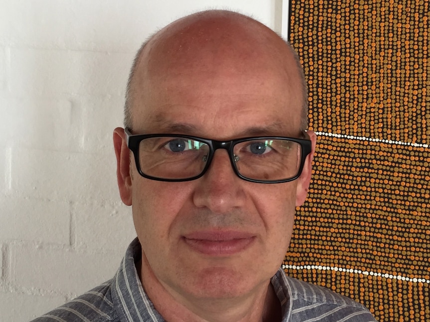 Scientist Eddie Holmes wearing glasses and a striped shirt.