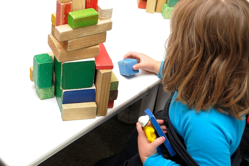 a child holding coloured blocks