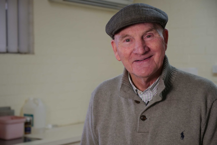 John Maxwell smiling at the camera in his rural vet clinic.