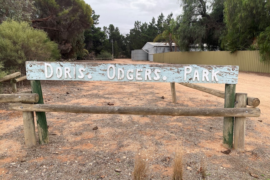 a weathered sign reading Doris Odgers Park on a dirt and rock driveway as an entrance to a Pioneer Museum