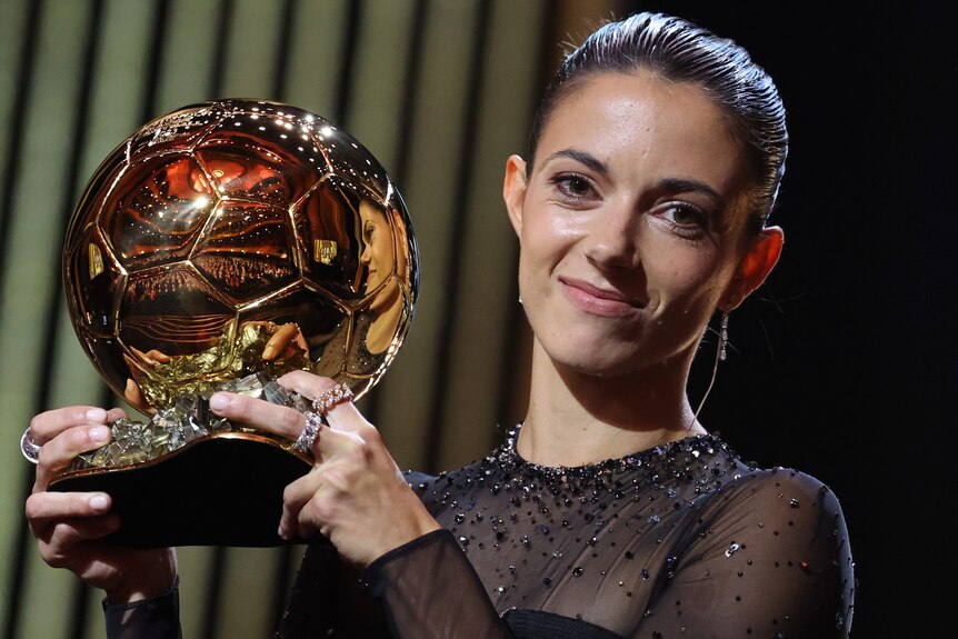 Aitana Bonmatí holds up the women's Ballon d'Or award.