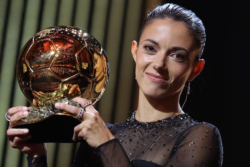 Aitana Bonmatí holds up the women's Ballon d'Or award.