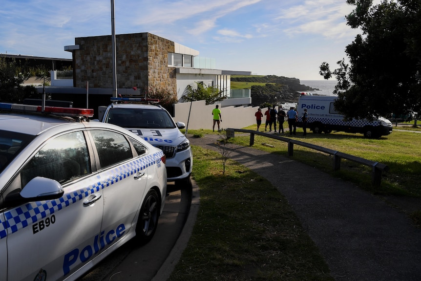 Police cars and officers at a park near the beach