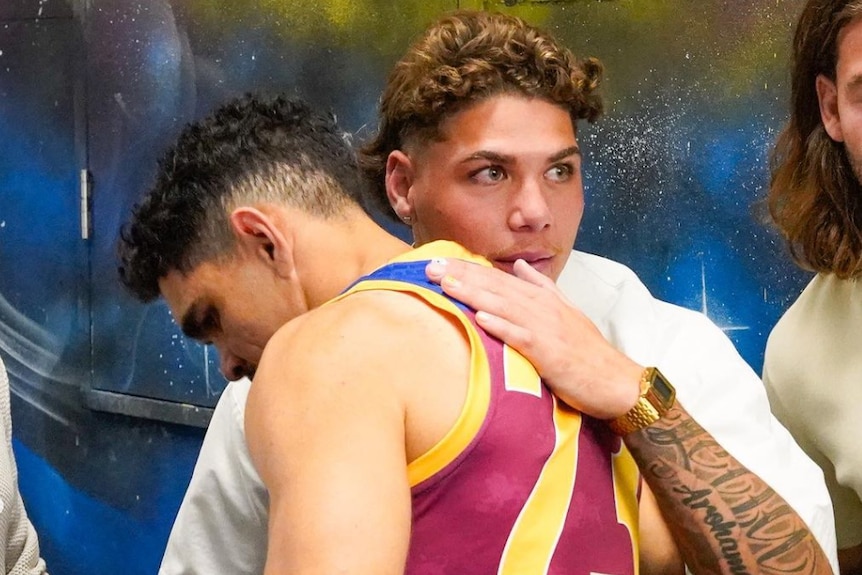 Reece Walsh and Charlie Cameron embrace in a hug