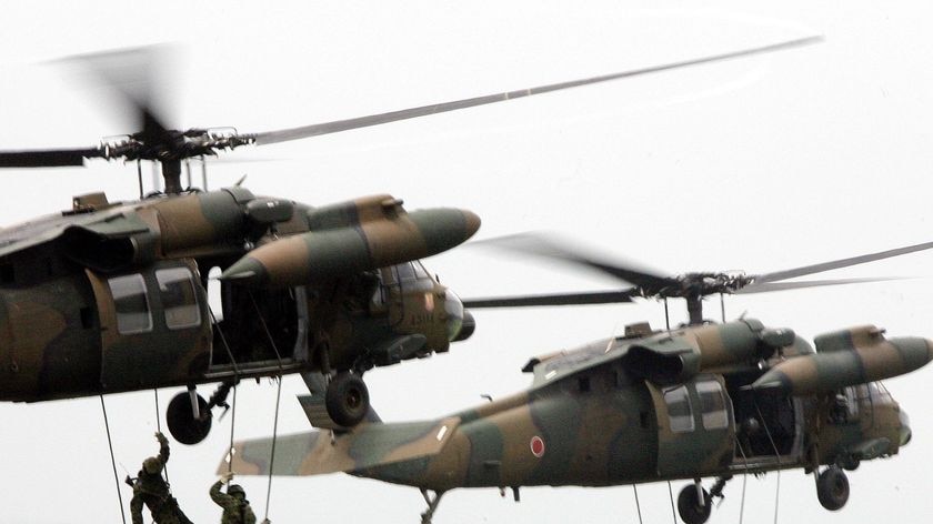 Japanese soldiers rappel from helicopters