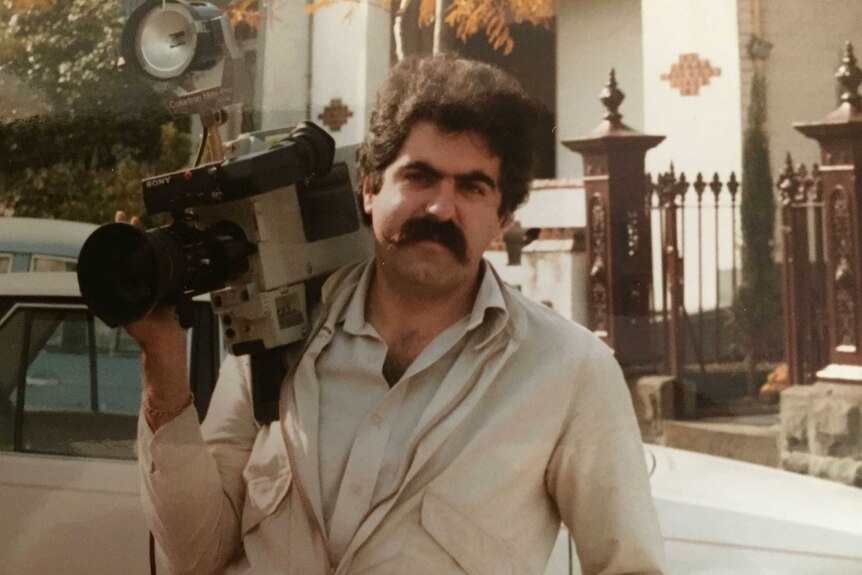 Vince Tucci holding early model camera on shoulder.