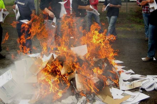 Young men burn copies of an early Basin Plan draft outside a Murray-Darling Basin Authority meeting in 2010.