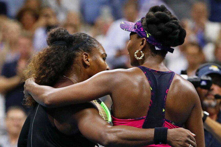 Two tennis players embrace and turn away from the camera