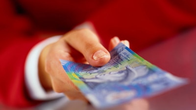 File photo: Holding a $10 note (Getty Creative Images)