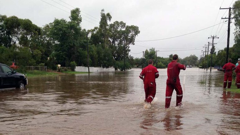Emergency workers wade through floodwaters in Roma