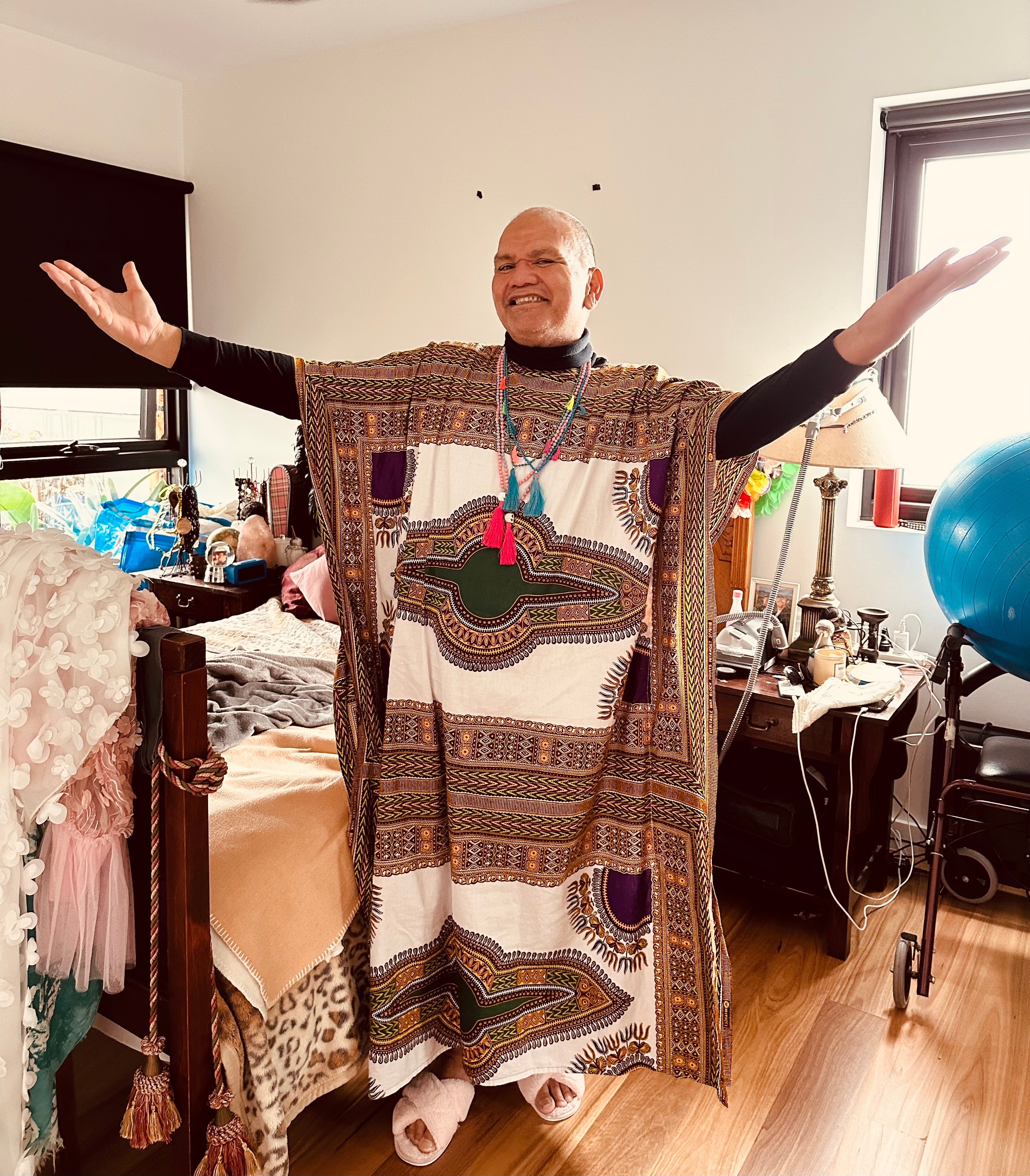 Man in a long kaftan smiles at the camera