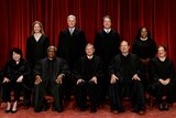 Supreme Court justices sitting and standing in black robes in official portrait.