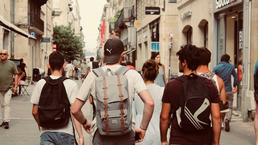 A group of boys walk along an urban street