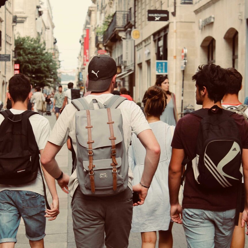 A group of boys walk along an urban street