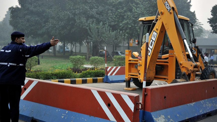 Bulldozer removes a barricade in front of US embassy in New Delhi